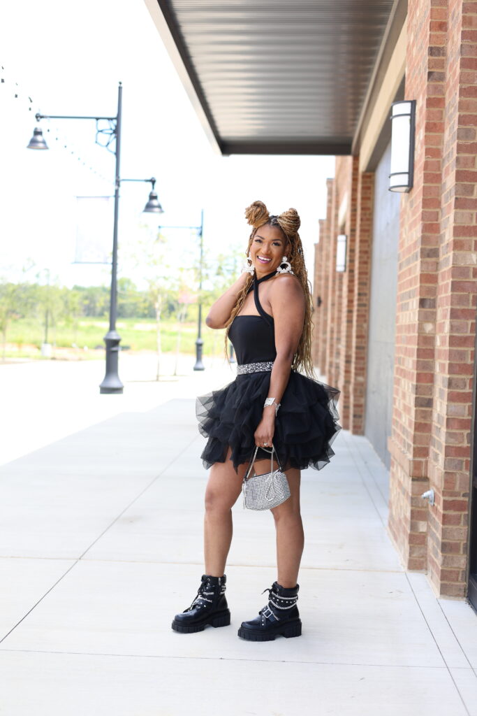 what to wear to a summer concert black tutu shorts criss cross bodysuit and black chain boots
